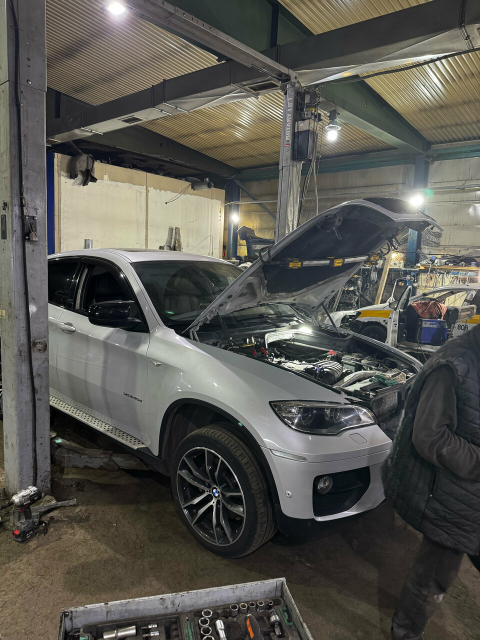Автомобиль с открытым капотом в рабочем боксе R. S. Service